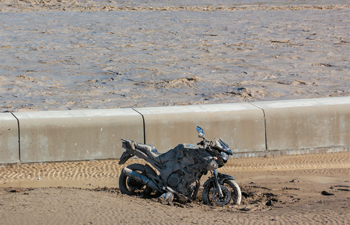 Illustration Motocyclette embourbée sur fond d'inondation ©Frédéric Ameye